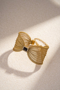 Bracelet manchette dorés en maille avec nœud bijou central